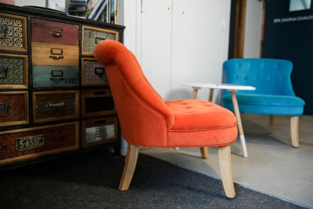 Le salon commun, avec son fauteuil orange, sa banquette bleue et son meuble à tiroirs colorés