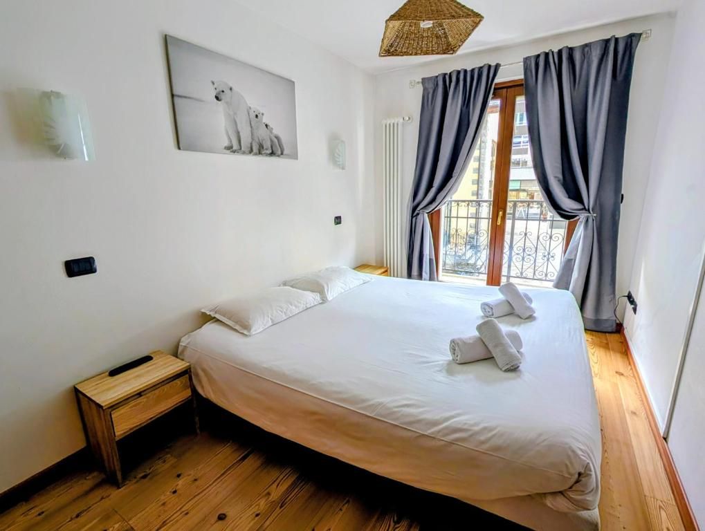 Une chambre à parquet clair, avec un très grand lit double et la fenêtre donnant sur la rue calme