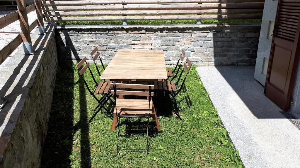 Le jardin de l’immeuble, avec sa longue table de bois et ses chaises, protégé par un mur de pierre