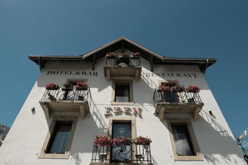 La façade blanche de l’hôtel, ses balcons de bois fleuris et son enseigne peinte entre les étages