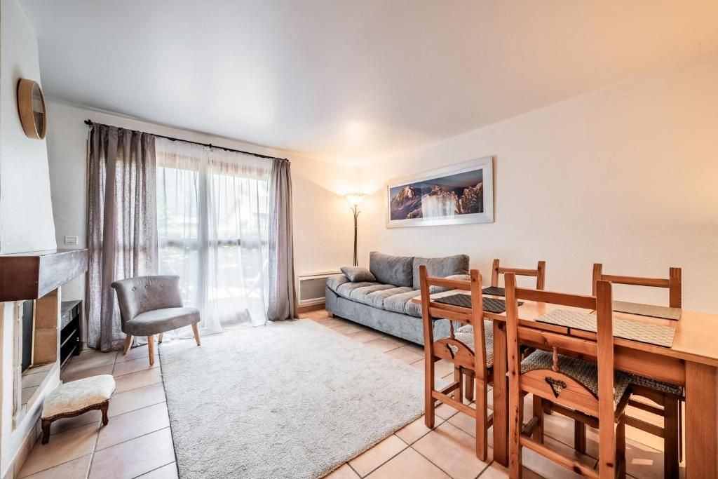 Le séjour d’un appartement, avec son canapé, sa table de repas et sa grande fenêtre
