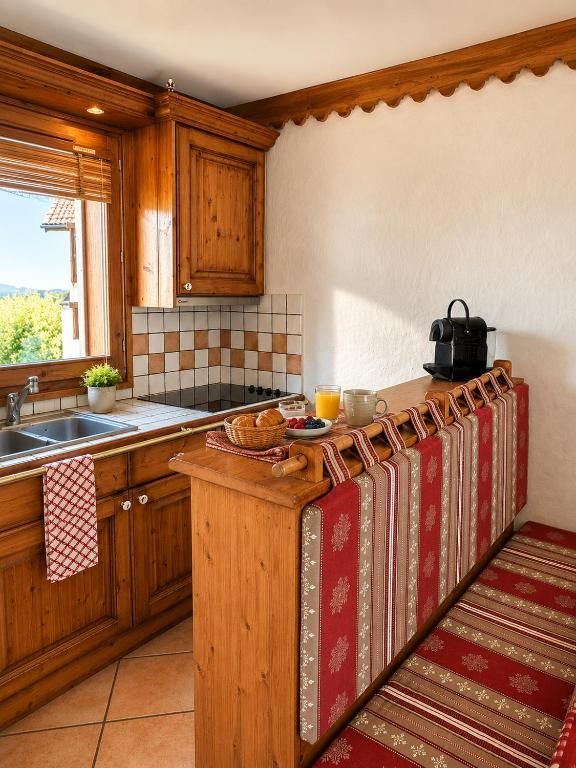 La cuisine en longueur, ses placards clairs, sa plaque et son plan de travail carrelé