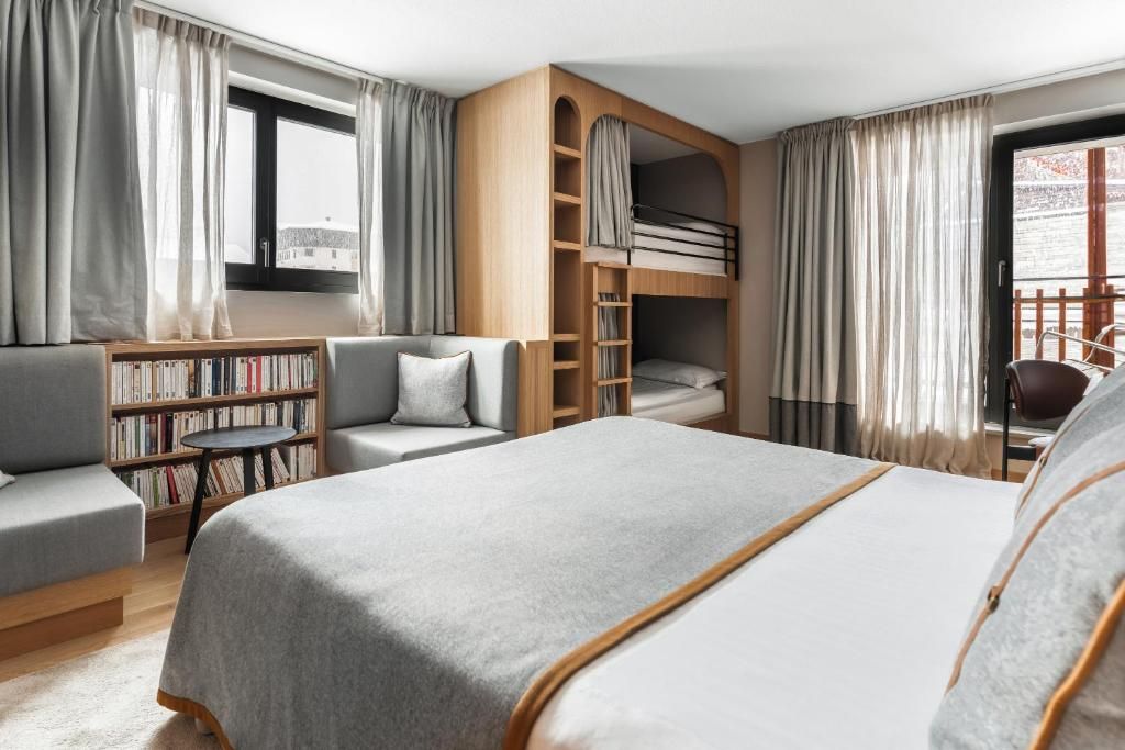 Une chambre familiale avec son grand lit, ses lits superposés encastrés et sa bibliothèque