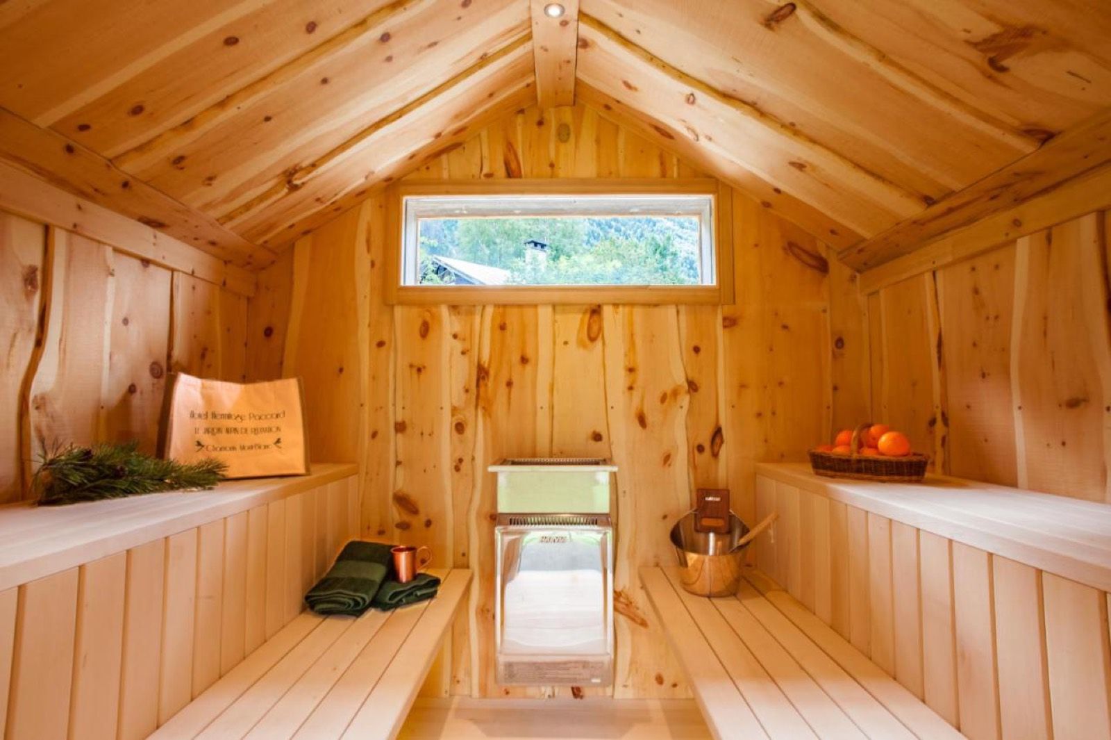 L’intérieur du sauna, entièrement en bois clair, avec son poêle