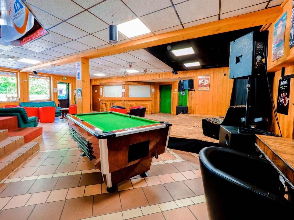 La salle de jeux, avec son billard, ses banquettes colorées et son écran au mur
