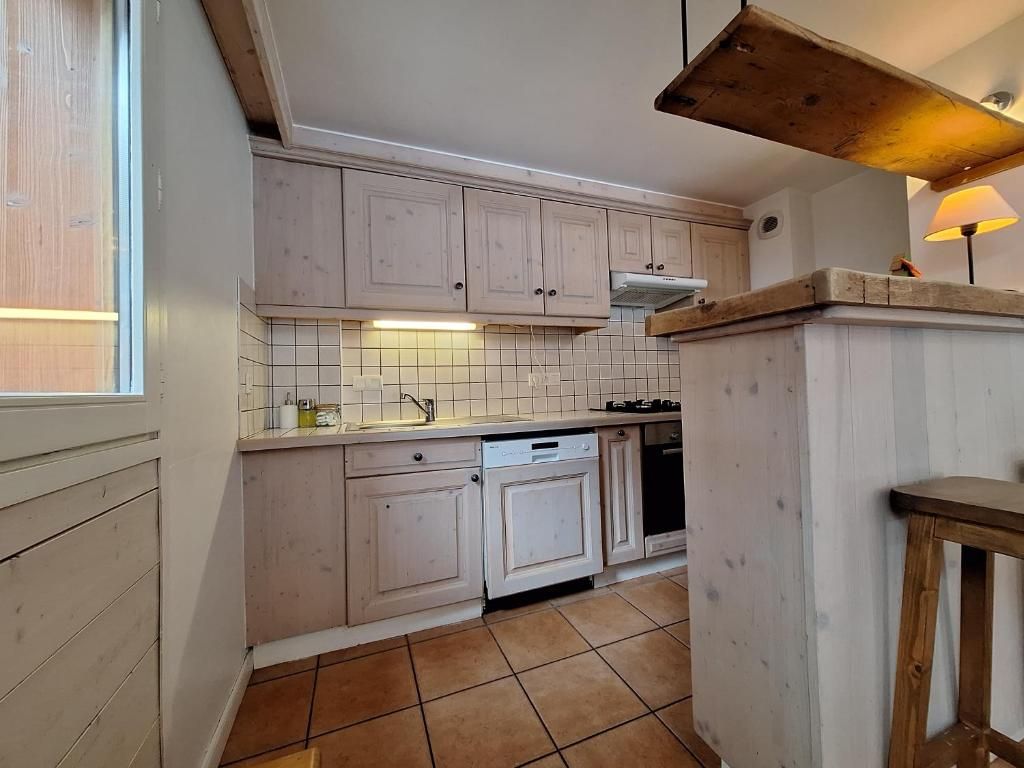 La cuisine ouverte du chalet, son plan de travail en longueur et sa table à manger devant la baie