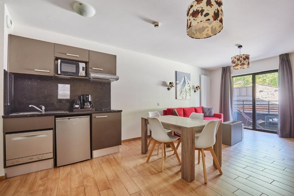 Un appartement avec sa kitchenette, sa table à manger et sa porte-fenêtre sur le balcon