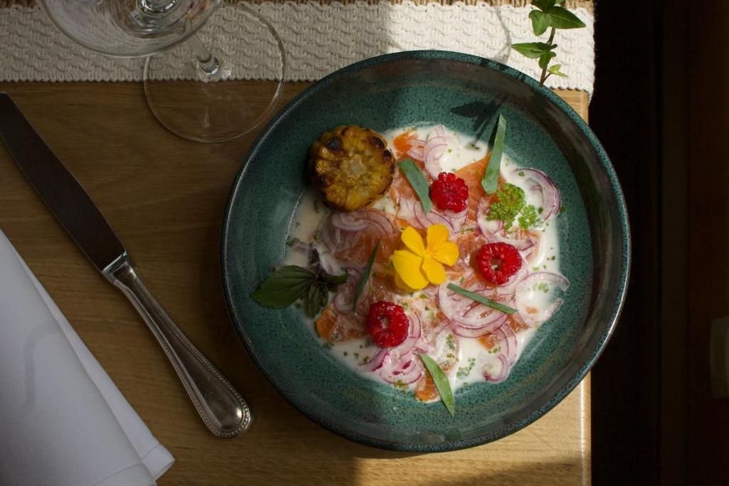 Une assiette du restaurant, dressée sur une table de bois avec ses couverts d’argent