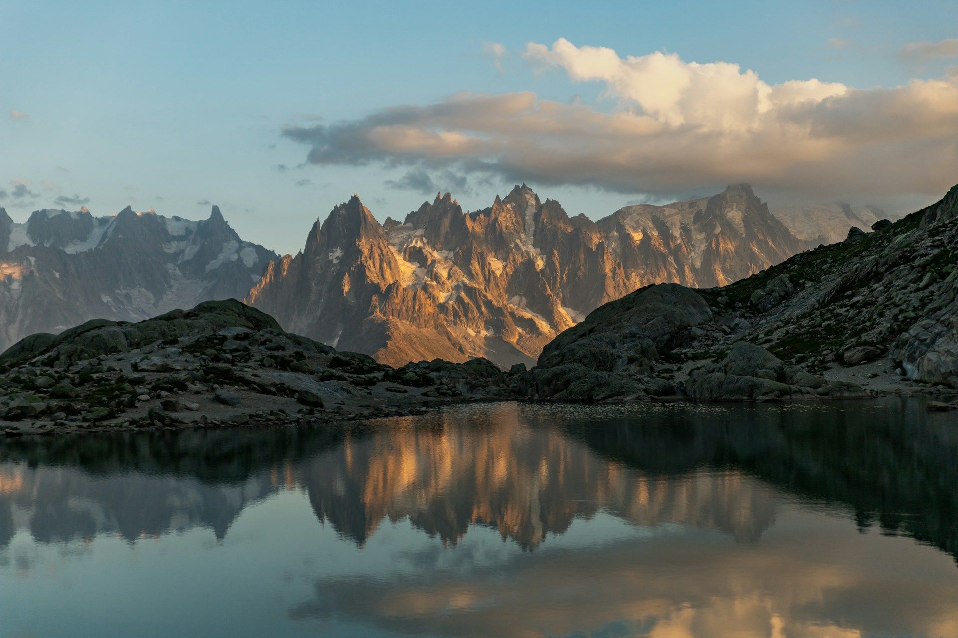 Un lac d’altitude du plateau des Aiguilles Rouges au lever du jour, la chaîne du Mont-Blanc reflétée dans l’eau