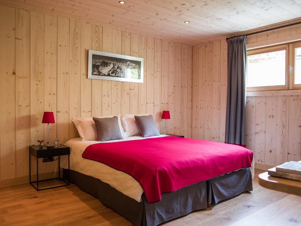 Une chambre entièrement lambrissée de bois clair, avec un grand lit double