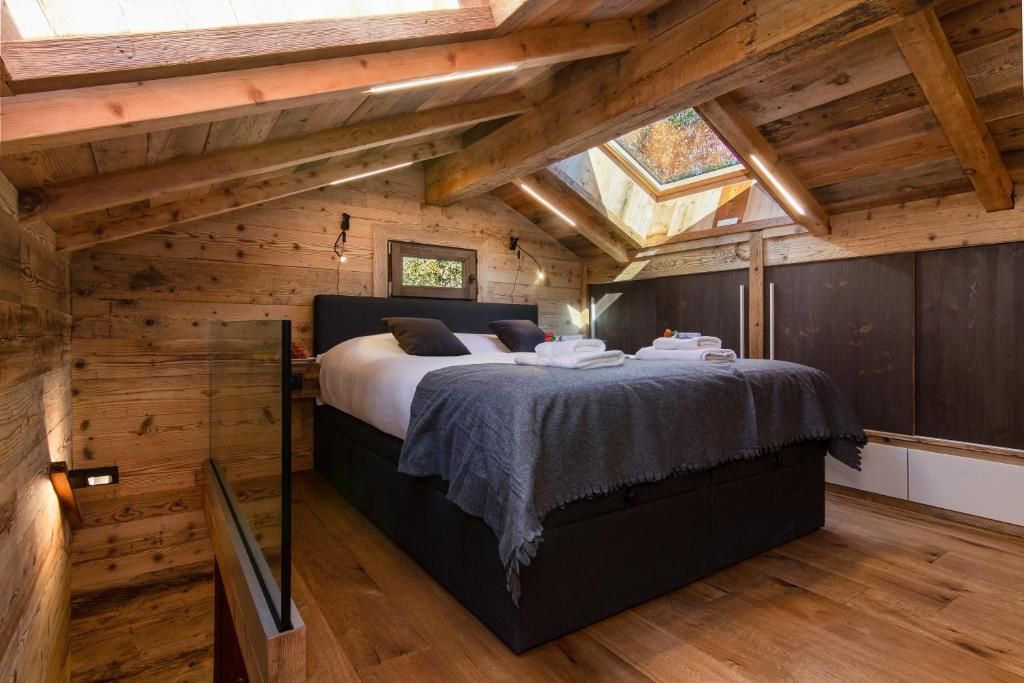 La chambre sous la charpente, avec son lit double et deux fenêtres de toit ouvertes sur le ciel