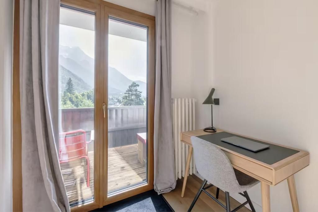 Le bureau installé devant la porte-fenêtre, avec sa lampe articulée et sa chaise