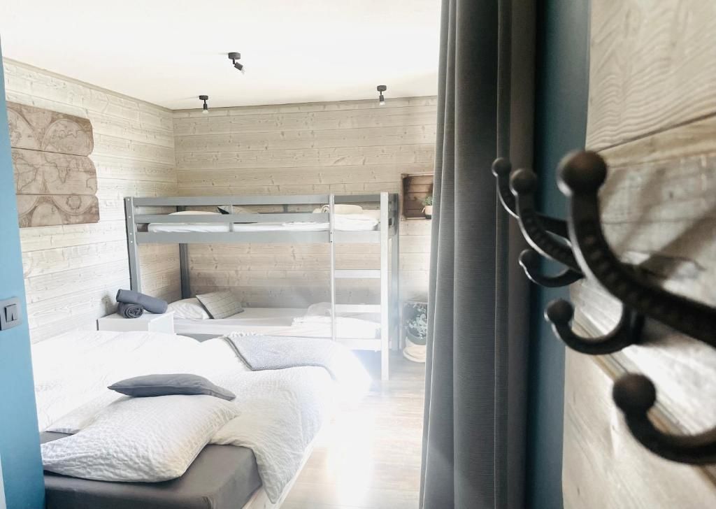 Une chambre à deux lits simples, en bois clair, sous la pente du toit