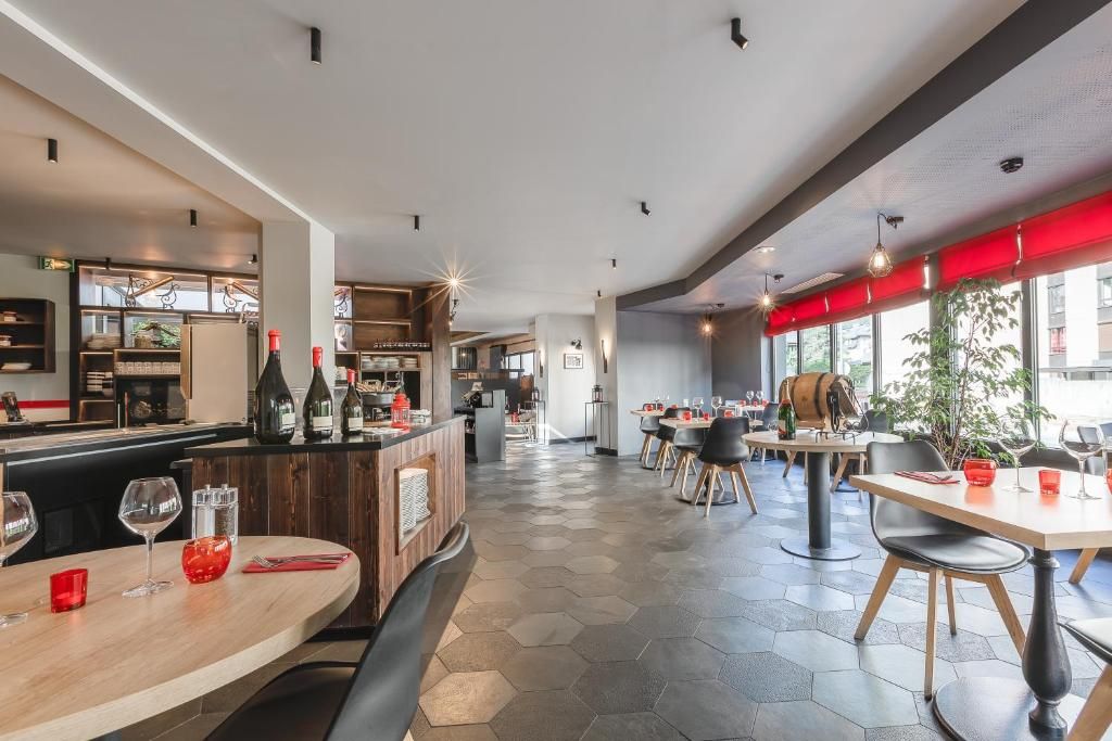 Le bar et la salle de restaurant, avec leur comptoir de bois et les grandes baies rouges sur le jardin