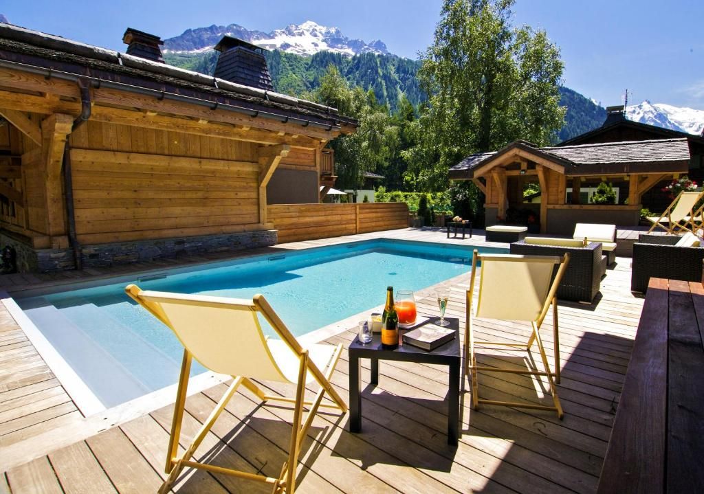 Le bassin intérieur du chalet sous sa charpente de bois, éclairé par une baie sur le jardin