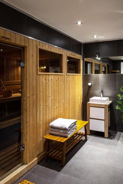 Le sauna de bois clair, ses gradins et sa vitre donnant sur le couloir