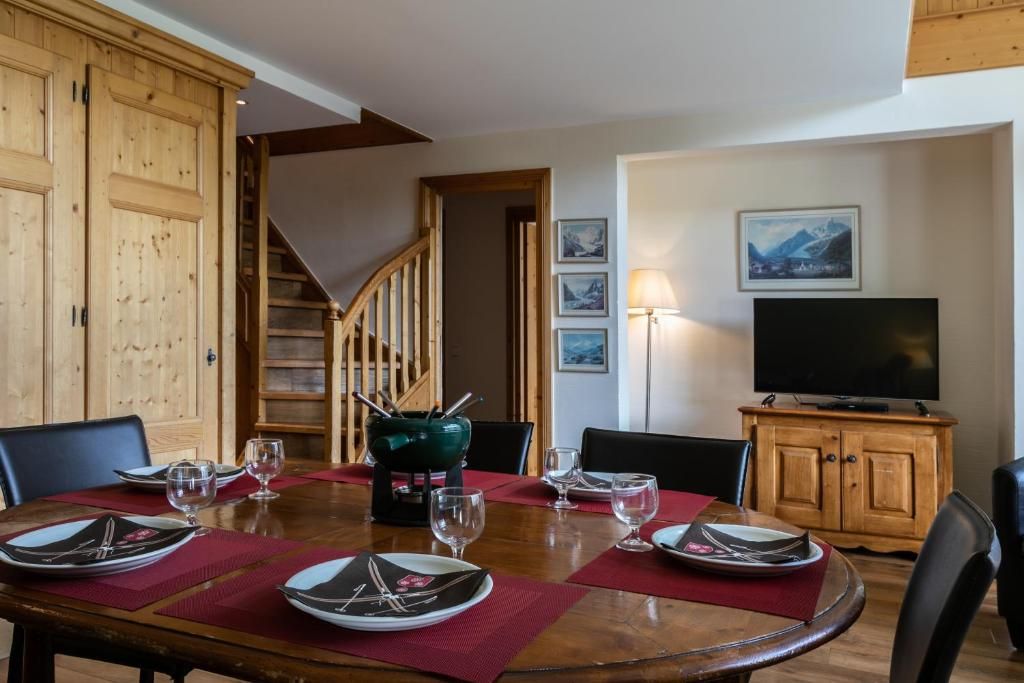 Le séjour d’une suite, sa table ronde dressée, son coin télévision et l’escalier vers l’étage