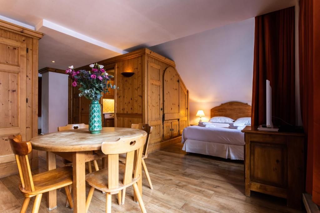 Une suite avec sa table à manger de bois, son lit au fond et son armoire de sapin
