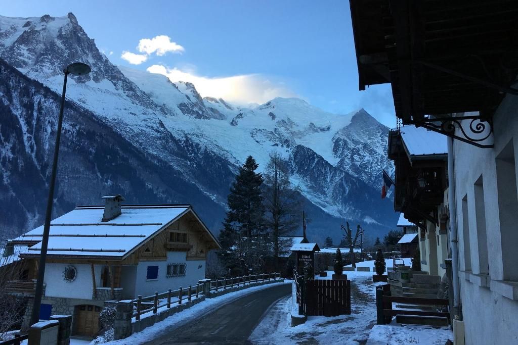 La rue enneigée devant la maison, avec les toits chargés de neige et une aiguille du massif au fond