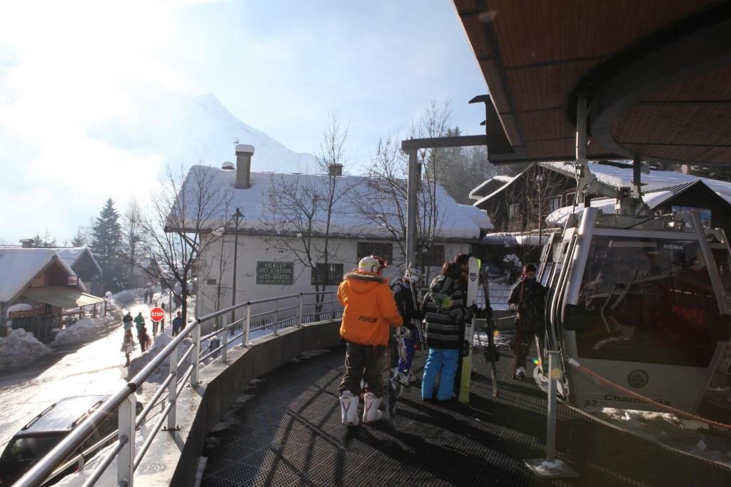 La rampe d’accès à la télécabine, longée d’une rambarde, sous un ciel chargé de neige